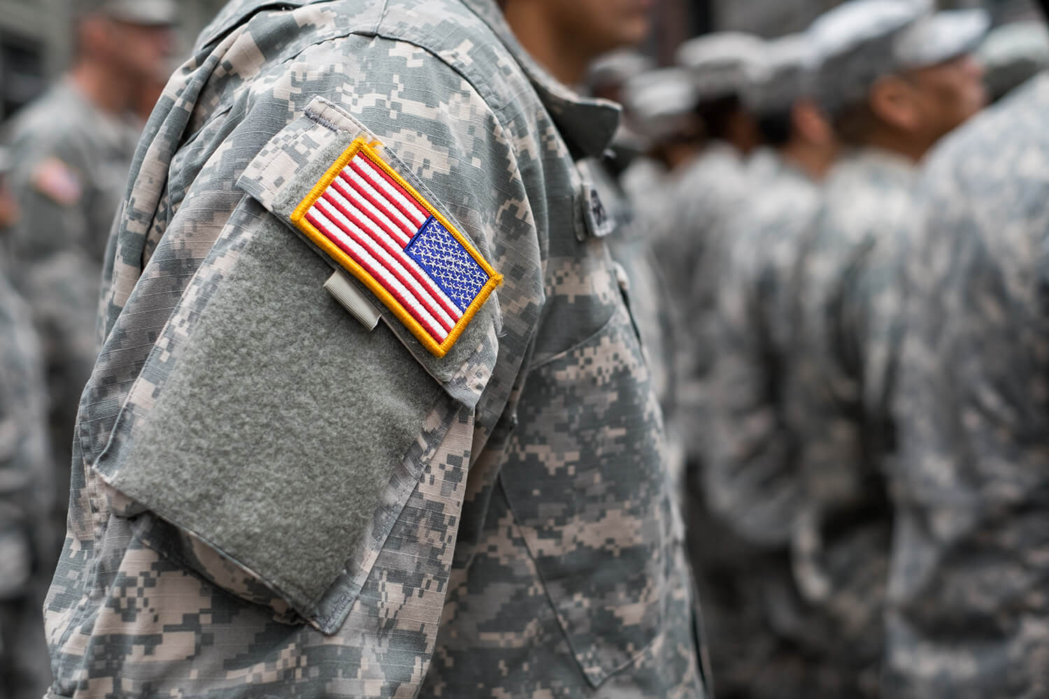 military patches on a soldier in line with other fellow soldiers